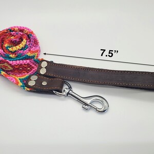 Op de afbeelding: Een kleurrijke geweven hondenriem met een bruin leren band en een zilveren haak. De riem is 7,5 inch lang.