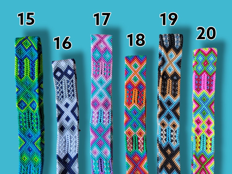 Op de afbeelding: Een set van tien kleurrijke geweven vriendschapsarmbanden met verschillende geometrische patronen. De armbanden zijn genummerd van 15 tot 20.