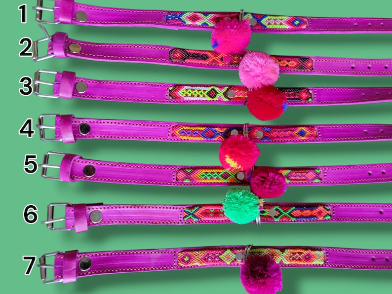 May include: Seven bright pink leather collars numbered one through seven, each featuring a unique woven fabric inlay with geometric patterns and a single colorful yarn pom-pom attached to a metal ring near the center of the strap.