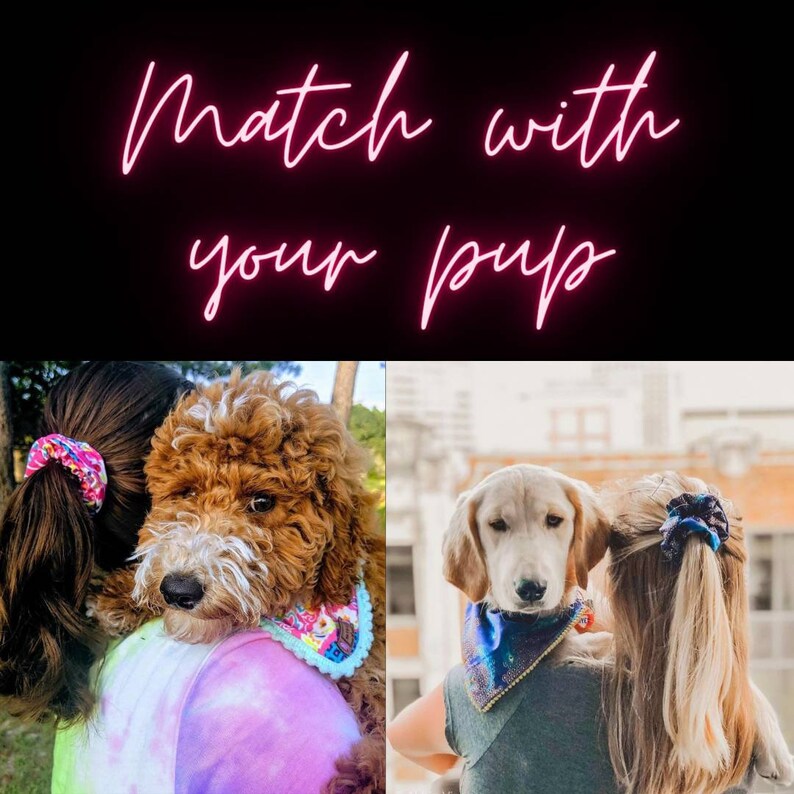 May include: Two women are holding their dogs. Both women are wearing scrunchies in their hair and their dogs are wearing bandanas. The text "Match with your pup" is displayed in pink neon letters.