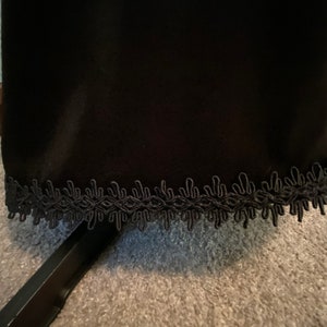May include: Black skirt with a black lace trim around the bottom.
