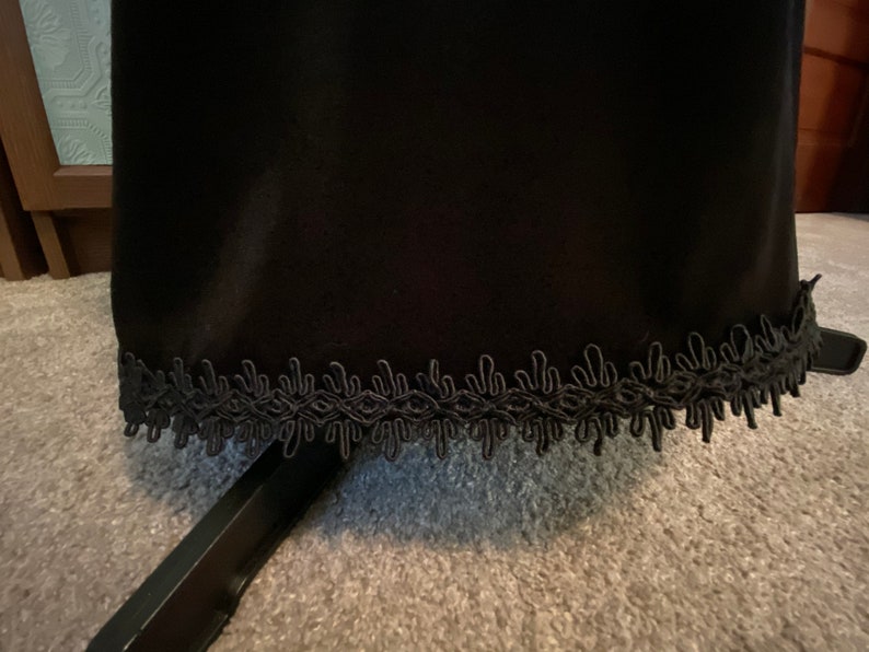 May include: Black skirt with a black lace trim around the bottom.