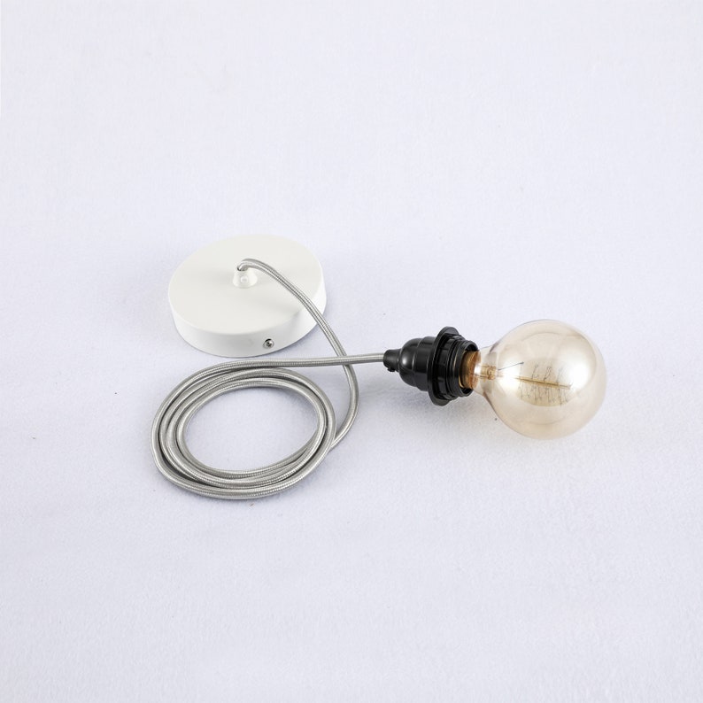 May include: A white ceiling fixture with a black cord and a clear glass light bulb. The cord is coiled and the fixture is attached to the ceiling.