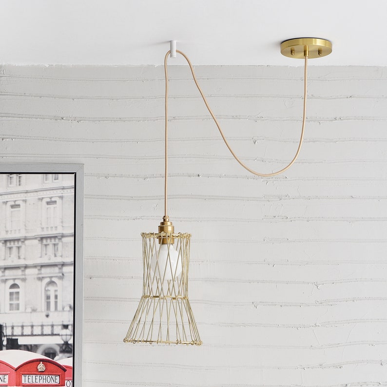 A transformable gold wire shade pendant hung and swag to position on a white Easy Hook mounted on a white ceiling.