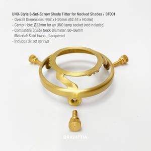 May include: A brass UNO-style 3-set-screw shade fitter for necked shades. Overall dimensions are 2.44 inches in diameter and 0.8 inches high. The center hole is 0.33mm for an UNO lamp socket. Includes 3 set screws. The text "BRIGHTTIA" is visible.