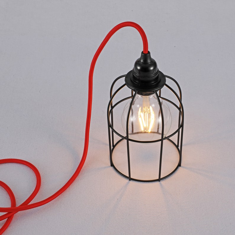 May include: A black metal cage pendant light with a clear glass bulb and a red cord.