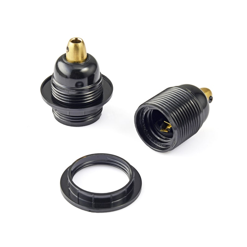 May include: Three black ceramic light bulb sockets with gold-colored metal parts. The sockets are designed for use with standard light bulbs.