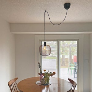 Black Easy Hook used to swag black wire shade pendant to the center of dining table. Ceiling electrical junction box is not centered.