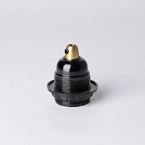 May include: Black and brass light bulb socket with a threaded base.