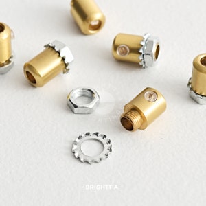May include: A set of six gold-toned metal cord end caps with a threaded end and a small clear plastic insert. The set also includes a silver-toned washer and nut.