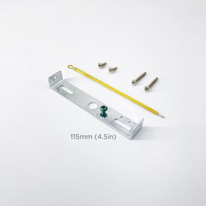 May include: A silver metal bracket with a green screw and a yellow wire. The bracket is 4.5 inches long and comes with four screws.