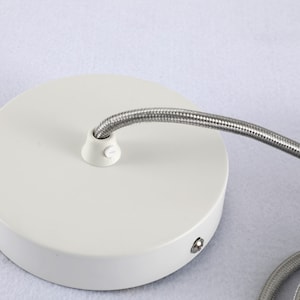 May include: White ceiling rose with a silver cord attached. The ceiling rose has a screw on the bottom.