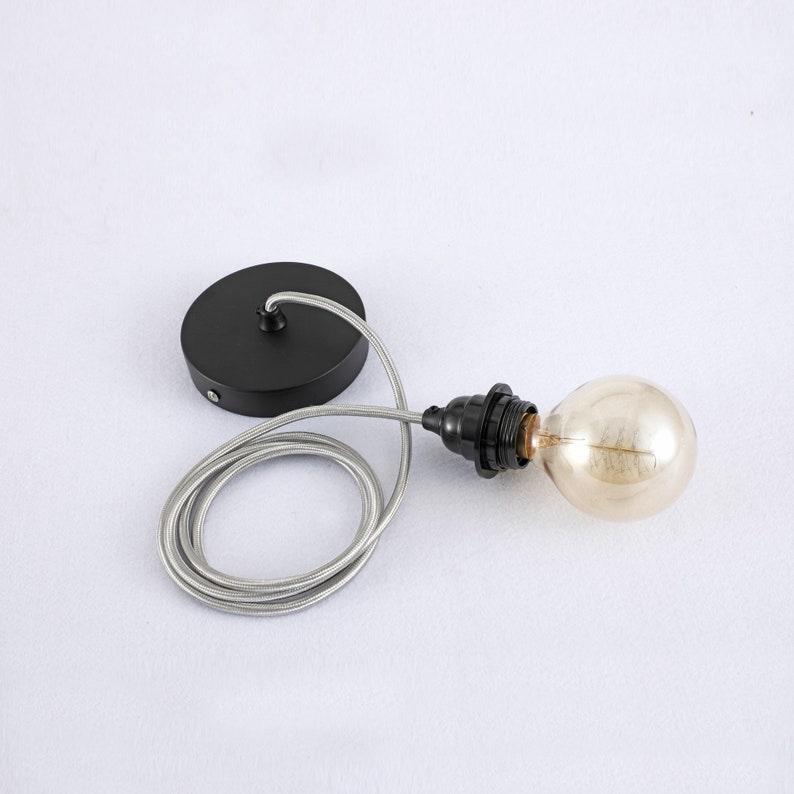 May include: Black ceiling light fixture with a silver cord and a clear glass bulb.