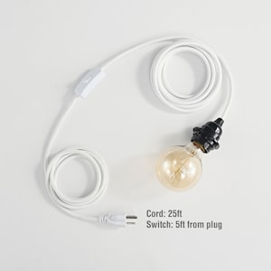 Puede incluir: Un cable eléctrico blanco con una toma negra y una bombilla. El cable tiene un interruptor en línea y un enchufe. Cable: 7,6 m Interruptor: 1,5 m del enchufe