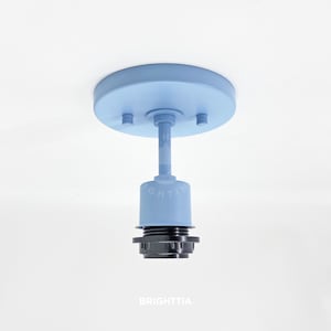 Puede incluir: Una lámpara de techo de color azul claro con una cubierta redonda y un solo casquillo. La lámpara está hecha de metal y tiene un diseño simple y moderno.