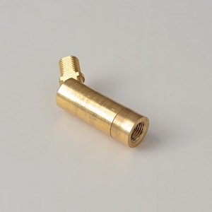 May include: A brass pipe fitting with a threaded end and a 90-degree angle. The fitting is designed for connecting pipes or hoses.