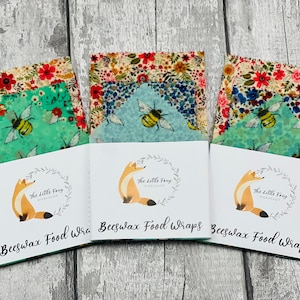 May include: Three sets of beeswax food wraps with floral and bee designs. Each set is packaged in a white card with a fox logo and the text "The Little Foxy Workshop" and "Beeswax Food Wraps".