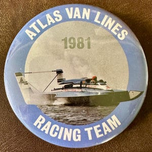 May include: A blue and white button with the text "Atlas Van Lines 1981 Racing Team" in a white circle. A photo of a blue and white hydroplane boat is in the center of the button.