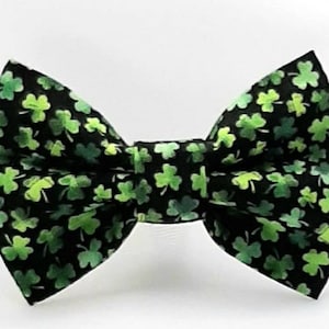 May include: A black bow tie with a green shamrock pattern.