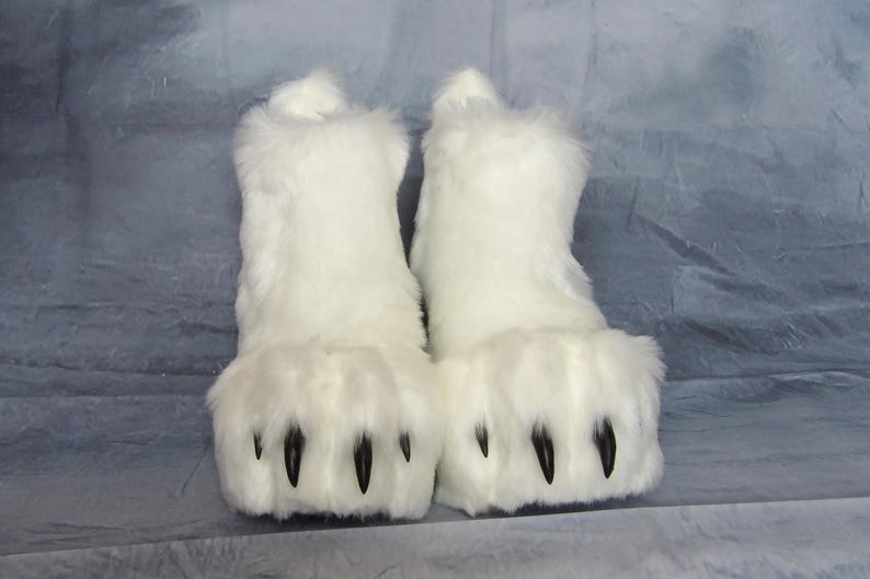 Puede incluir: Un par de botas blancas y peludas con grandes pies en forma de pata. Las botas tienen garras negras y est&aacute;n hechas de un material suave y afelpado. Las botas est&aacute;n dise&ntilde;adas para parecerse a patas de animales.