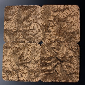 Puede incluir: Cuatro posavasos de madera con mapas topográficos de cuatro montañas: Mount Elbert, Mount Massive, Mount Harvard y Blanca Peak. Cada posavasos tiene el nombre de la montaña y la altitud impresa en la parte inferior.