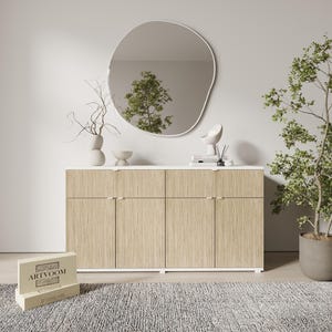 May include: A modern, light wood-grain cabinet with four doors and gold-toned handles. A white countertop supports decorative items and a large, organic-shaped mirror. A potted plant and a rug complete the room's decor.
