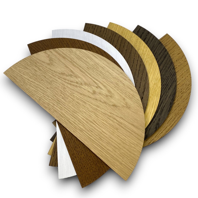 May include: A set of eight wood veneer samples in various shades of brown, from light to dark, arranged in a fan shape. The samples are in the shape of half circles.