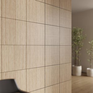 May include: Light-coloured wooden wall paneling with a grid pattern. The rectangular panels have a vertical wood grain. The wall is in a room with a blurred background, including plants in white pots.