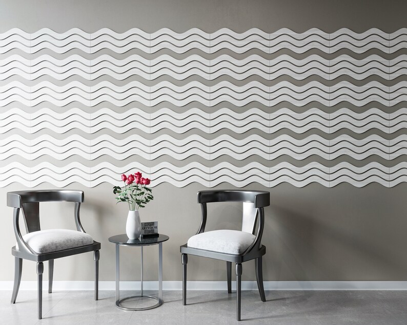 May include: Two black chairs with white cushions and a small round glass table with a vase of red roses. The wall behind the furniture is decorated with a white wave pattern.