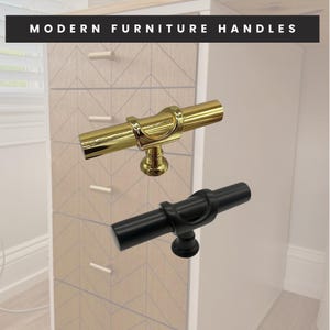 May include: Gold and black modern furniture handles. The gold handle is shiny and the black handle is matte. The handles are cylindrical with a curved accent. The text "MODERN FURNITURE HANDLES" is at the top of the image.