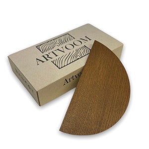 May include: A brown wooden half-circle shelf with a natural wood grain finish. The shelf is packaged in a brown cardboard box with the word "ARTVOOM" printed on the top.