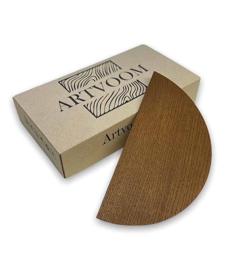 May include: A brown wooden half-circle shelf with a natural wood grain finish. The shelf is packaged in a brown cardboard box with the word "ARTVOOM" printed on the top.
