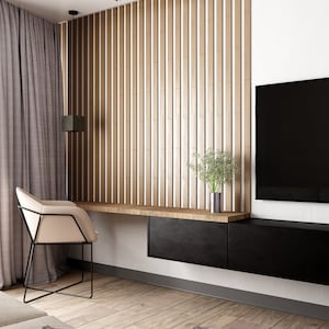 May include: A modern living room with a wooden slat wall, a black TV, a black desk with a beige chair, and a brown wooden floor.