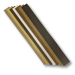 May include: A set of seven long, rectangular wooden strips arranged in a diagonal fan pattern. The strips feature various wood grain finishes, ranging from light tan and golden oak to medium brown, dark espresso, and a solid off-white color.
