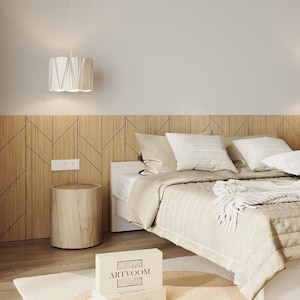 May include: A bedroom featuring a light wood wall panel with a geometric pattern, a white bed with beige bedding, two white pendant lights, a cylindrical light wood nightstand, and a white box with the text ARTVOOM printed on the front.