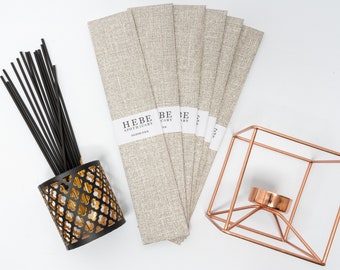 May include: A set of six incense sticks packaged in beige paper with the text "HEBE APOTHICARY INCENSE STICK" printed on the front. The sticks are in a black holder with gold accents. A copper candle holder is also shown in the image.
