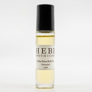 May include: A clear glass roller bottle with a black cap and a white label that reads "HEBE APOTHECARY Pulse Point Roll-On Grounded 10ml".