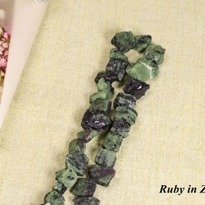 May include: A strand of green and black gemstone beads, with the text "Ruby in Zoisite" below.