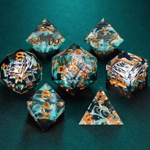 Può includere: Un set di sette dadi poliedrici in resina trasparente con inclusioni vorticose color ottanio e nero simili a fumo e accenti in foglia d'argento. Ogni dado presenta numeri incisi riempiti con una vernice metallizzata color rame.