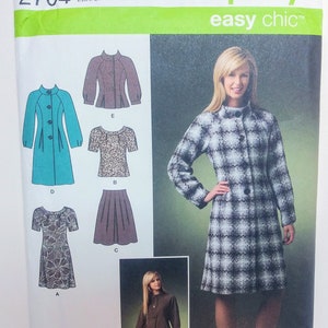 May include: Simplicity sewing pattern number 2764, easy chic, for sizes D5 4, 6, 8, 10, 12, EUR 30-38, FR 32-40. The pattern includes instructions for making a jacket, a skirt, and a dress. The jacket is shown in a black and white plaid pattern, the skirt is brown, and the dress is a floral print.
