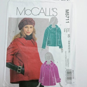 May include: A sewing pattern for a women's jacket. The pattern includes three different styles: a red jacket, a teal jacket, and a pink jacket. The pattern is for sizes 6-8-10-12-14. The pattern is from McCall's and the pattern number is M5711/A5.