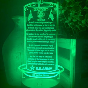 May include: A green illuminated candle with a flame on top. The candle has a white inscription that reads "Deployment Candle". The inscription continues with a poem about a soldier serving in the U.S. Army. The inscription ends with "U.S. Army" and "1SG Matthew Johnson".