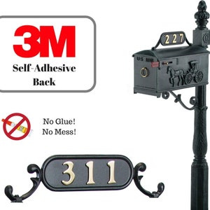 May include: Black metal mailbox with a horse-drawn carriage design and a 3M self-adhesive back. The mailbox has a US Mail label and a number 227 on the top. A separate black metal house number plaque with the number 311 is also shown.