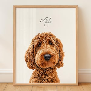 Op de afbeelding: Een ingelijst portret van een bruine Goldendoodle-hond met de naam "Milo" in script boven de kop van de hond. De hond heeft een pluizige, krullende vacht en een zwarte neus. De lijst is van lichtgekleurd hout.