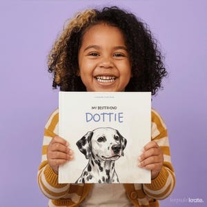 Może przedstawiać: Kwadratowa książka w twardej oprawie zatytułowana My Bestfriend Dottie z białą okładką przedstawiającą czarno-białą ilustrację dalmatyńczyka. Napis My Bestfriend jest wydrukowany na czarno, a Dottie na niebiesko. To książka typu keepsake krate.