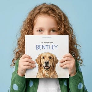 Może przedstawiać: Kwadratowa książka w twardej oprawie z białą okładką przedstawiającą realistyczną ilustrację psa rasy golden retriever. Tekst na okładce brzmi "a keepsake krate book" oraz "MY BESTFRIEND BENTLEY" czarnymi i niebieskimi literami.