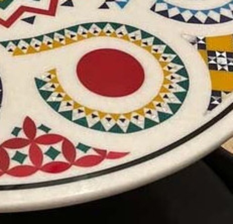 Puede incluir: Una mesa de m&aacute;rmol blanco con un dise&ntilde;o geom&eacute;trico colorido. El dise&ntilde;o presenta un c&iacute;rculo rojo, tri&aacute;ngulos amarillos y verdes y cuadrados negros y blancos.