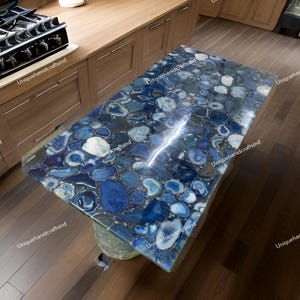 May include: A blue agate table top with a unique, natural pattern. The table top is made of many different pieces of agate, each with its own unique shape and color. The table top is polished to a high shine, and the agate pieces are arranged in a random pattern. The table top is perfect for a modern or contemporary home.