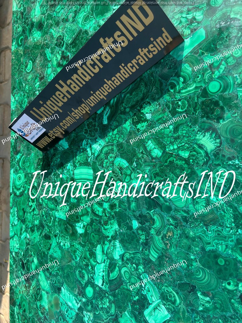 May include: A close-up of a green malachite stone surface with a black label that reads "Unique HandicraftsIND" and the website address "www.etsy.com/shop/uniquehandicraftsind".