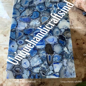 May include: A blue agate table top with a unique pattern of blue and white agate slices. The table top is made of natural stone and has a polished finish.
